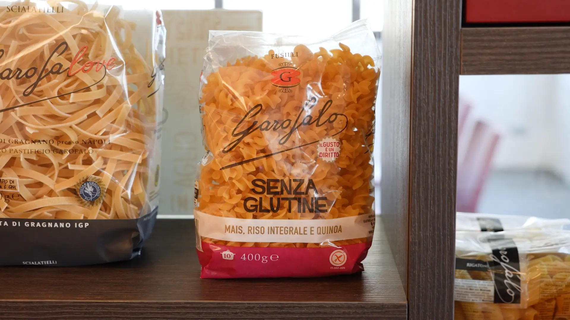 Bag of Garofalo gluten-free fusilli pasta on a shelf, labeled 'Senza Glutine' with corn, rice, and quinoa ingredients visible through the bag.