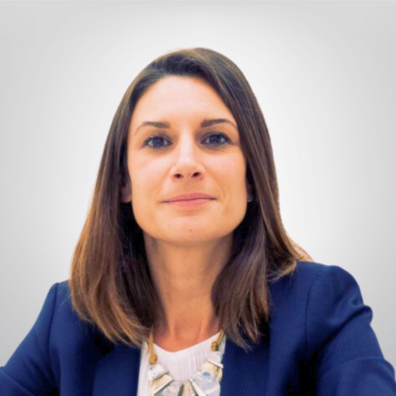 Professional woman with shoulder-length brown hair wearing a navy blazer, facing the camera.