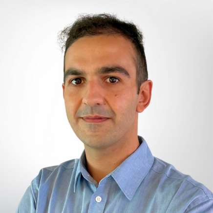 Head-and-shoulders portrait of a man wearing a light blue shirt, looking at the camera with a neutral expression.